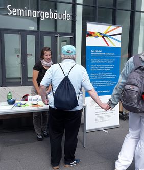 Blick auf den Stand - Mitarbeiter im Gespräch mit Besuchern