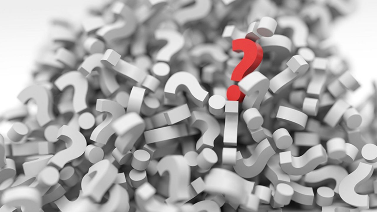 Grafik eines Haufens von Fragenzeichen - eines sticht rot heraus